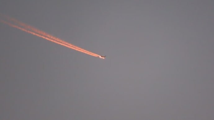 橙色に染まる飛行機雲