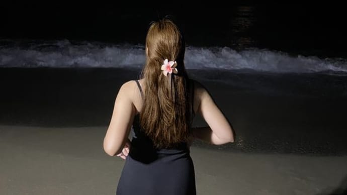 夜のビーチの黒いドレスの女子