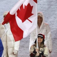 Joannie Rochette carries the Canadian flag