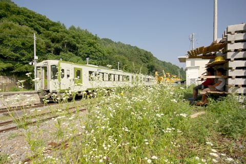 信濃川上駅に入る列車を見る小学生