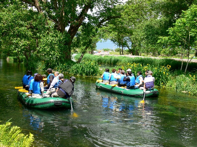 ”ワサビ大王農園”の清流では舟遊びする観光客