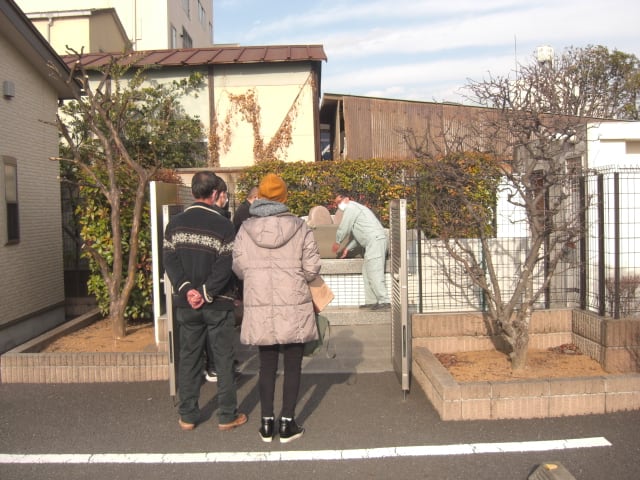職員さんが共同墓地の蓋を開けて、パウダー状にしたお骨を埋葬しています
