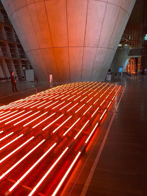 夜の美術館に赤い光の作品が浮かび上がります。写真奥にある逆円錐形のコンクリートコーンにも赤い光が反射しています