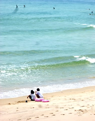 市後浜の渚で、サーファーを眺めるふたりの女の娘