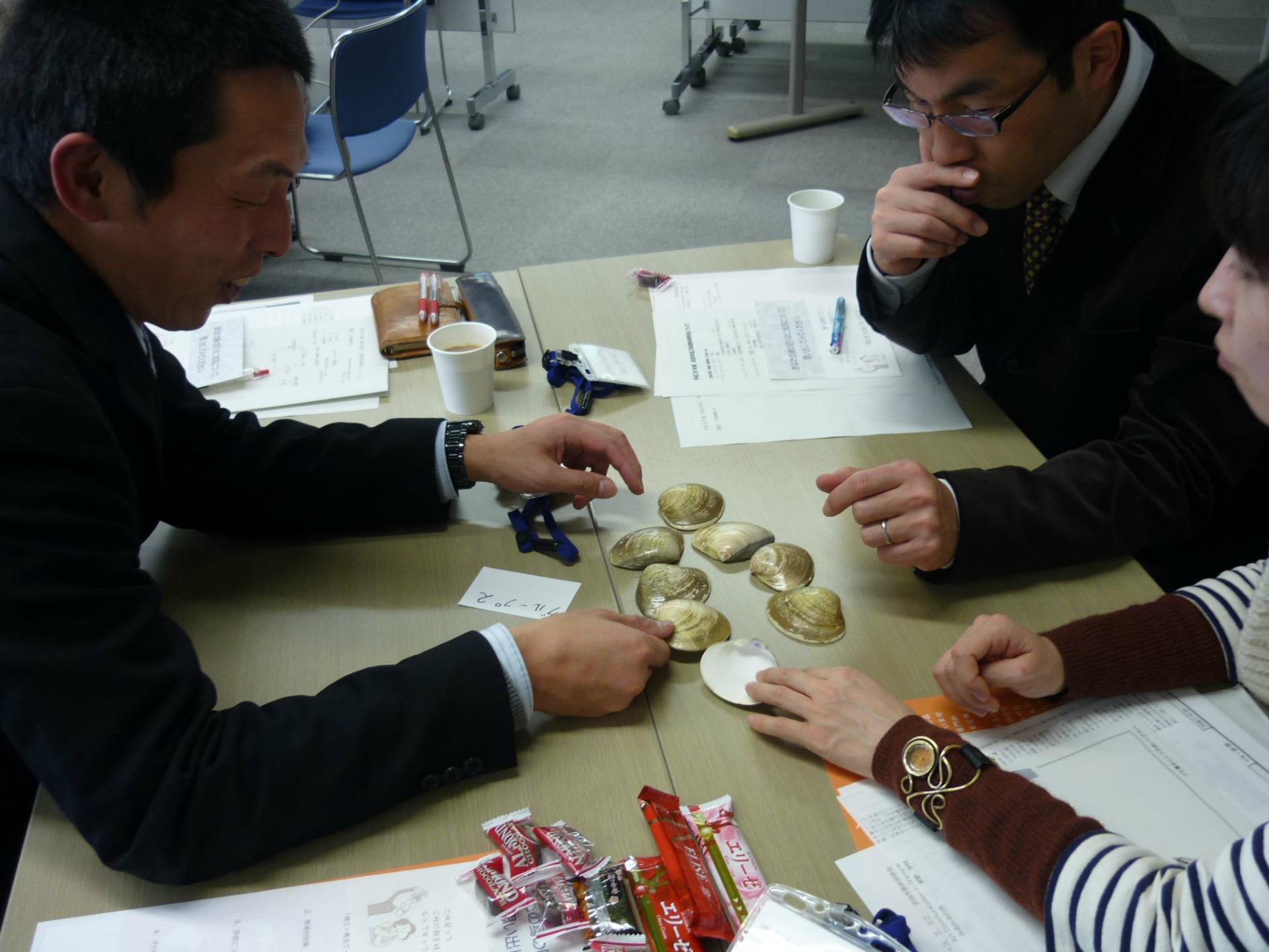 はまぐりの貝殻を手に取り思案にふける参加者の皆さん Art Communication In Shimane みるみるの会の活動報告