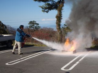 消防訓練１。風下から火元目掛けて消火器を噴射。写真のモデルは環境省米子事務所のレンジャーさん