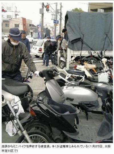 店頭からミニバイクを押収する捜査員