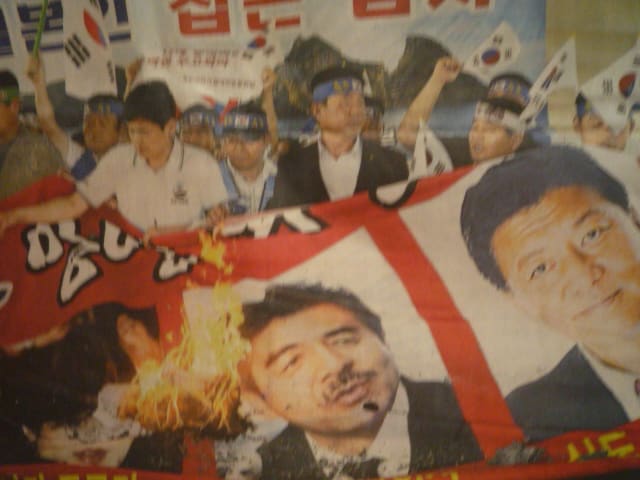 三人の写真を燃やす韓国の抗議者