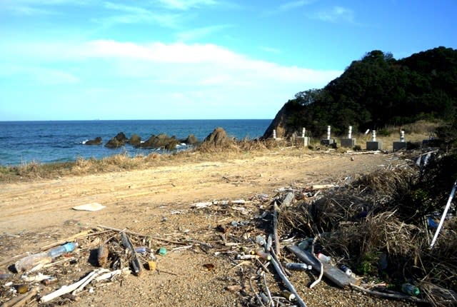 大野浜の防波堤の上に、無造作に打ちあがったままの流木とゴミ