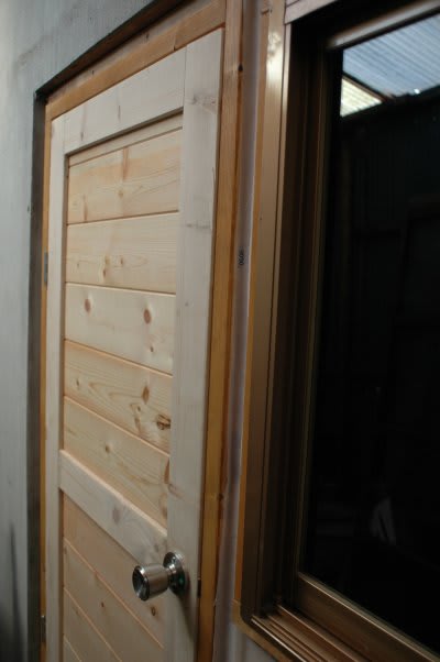 木製ドアを取付て外壁張りの段階になりました 木漏れ日のさすガーデン