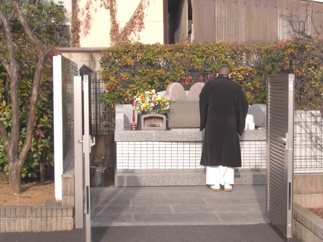 ペット専用共同墓地の前でお坊さんが読経